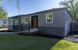 Contemporary stucco exterior with a stone veneer foundation