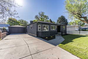 Modern exterior featuring dark gray stucco siding and a black stone facade