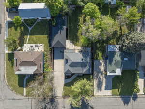 Property featuring a dark shingled roof, a paved driveway, and established landscaping