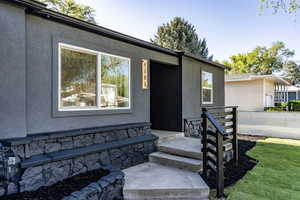 Contemporary exterior with dark stucco siding and a contrasting white-framed window