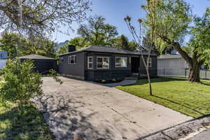 Modern exterior featuring dark gray siding and a contrasting stacked stone facade