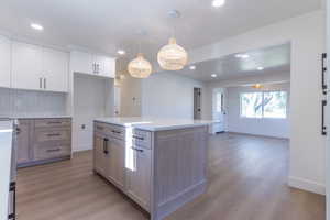 Kitchen island featuring light wood-finish cabinetry and a light-toned countertop