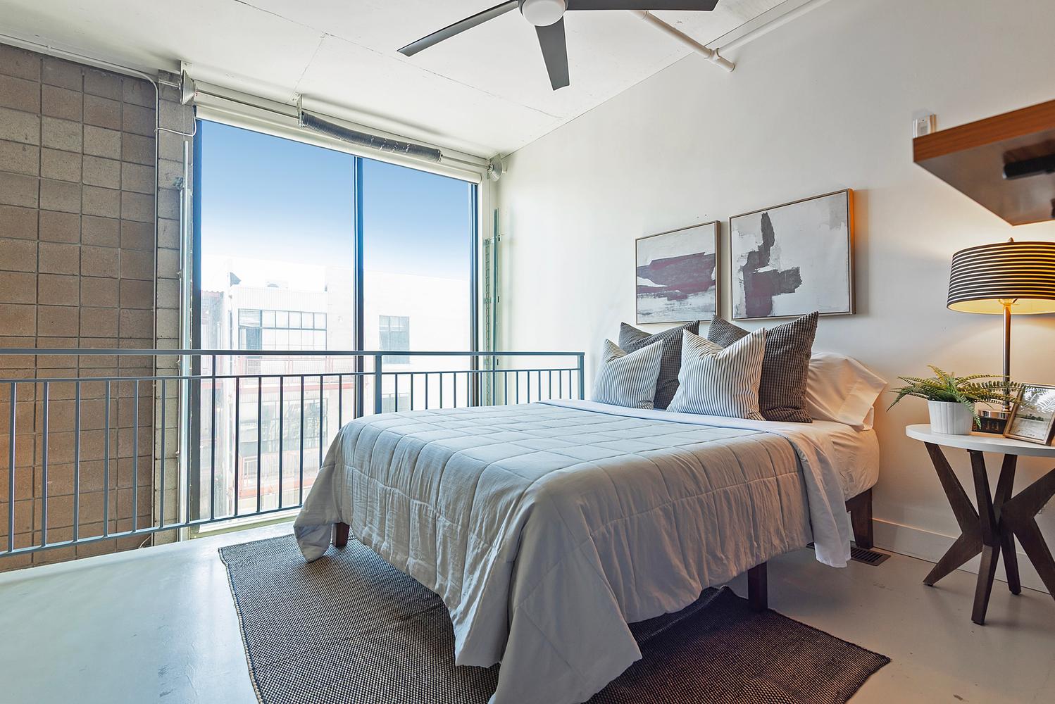 Expansive floor-to-ceiling windows with a metal railing