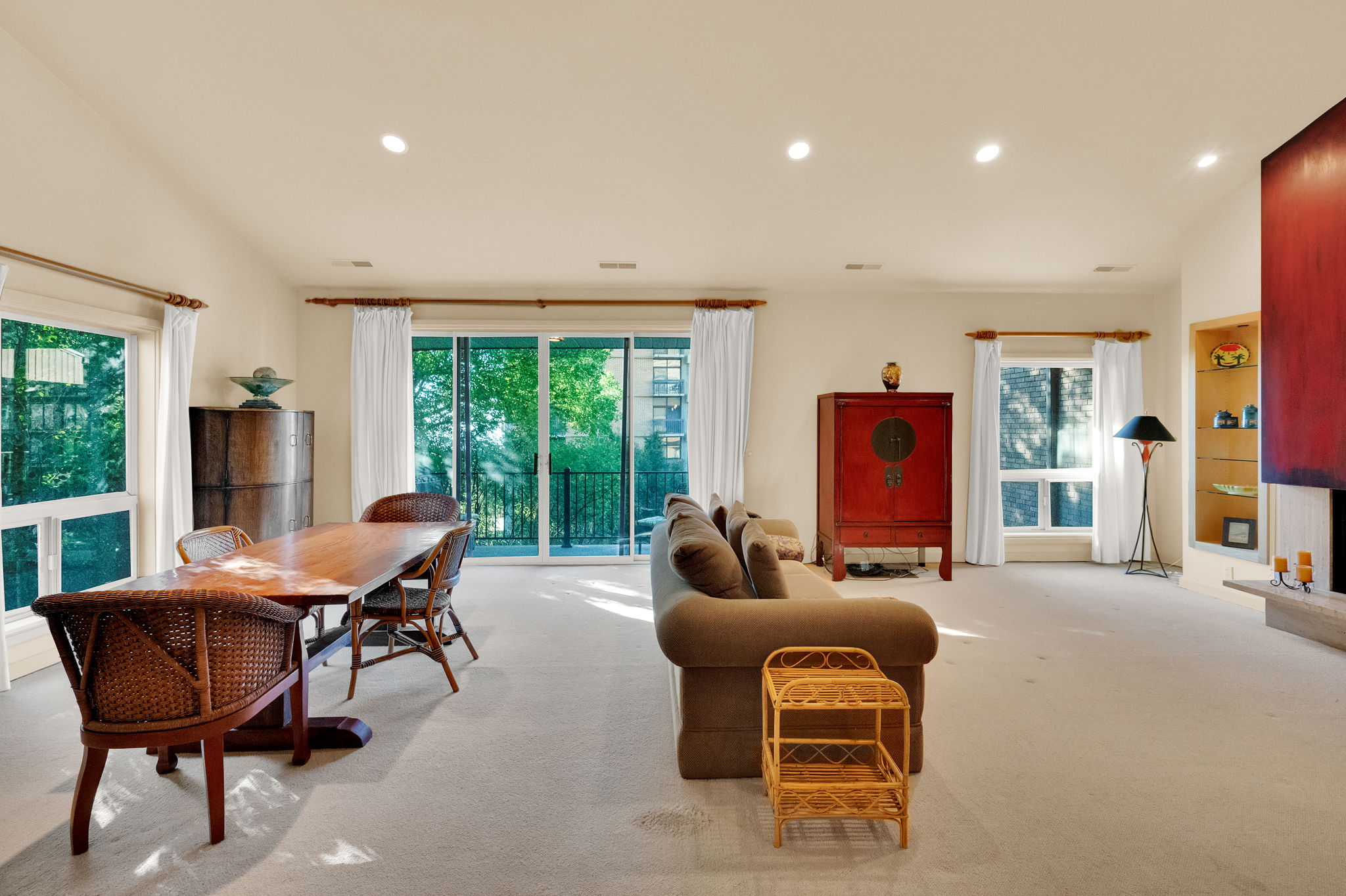 Open-concept living area with plush carpeting and recessed lighting