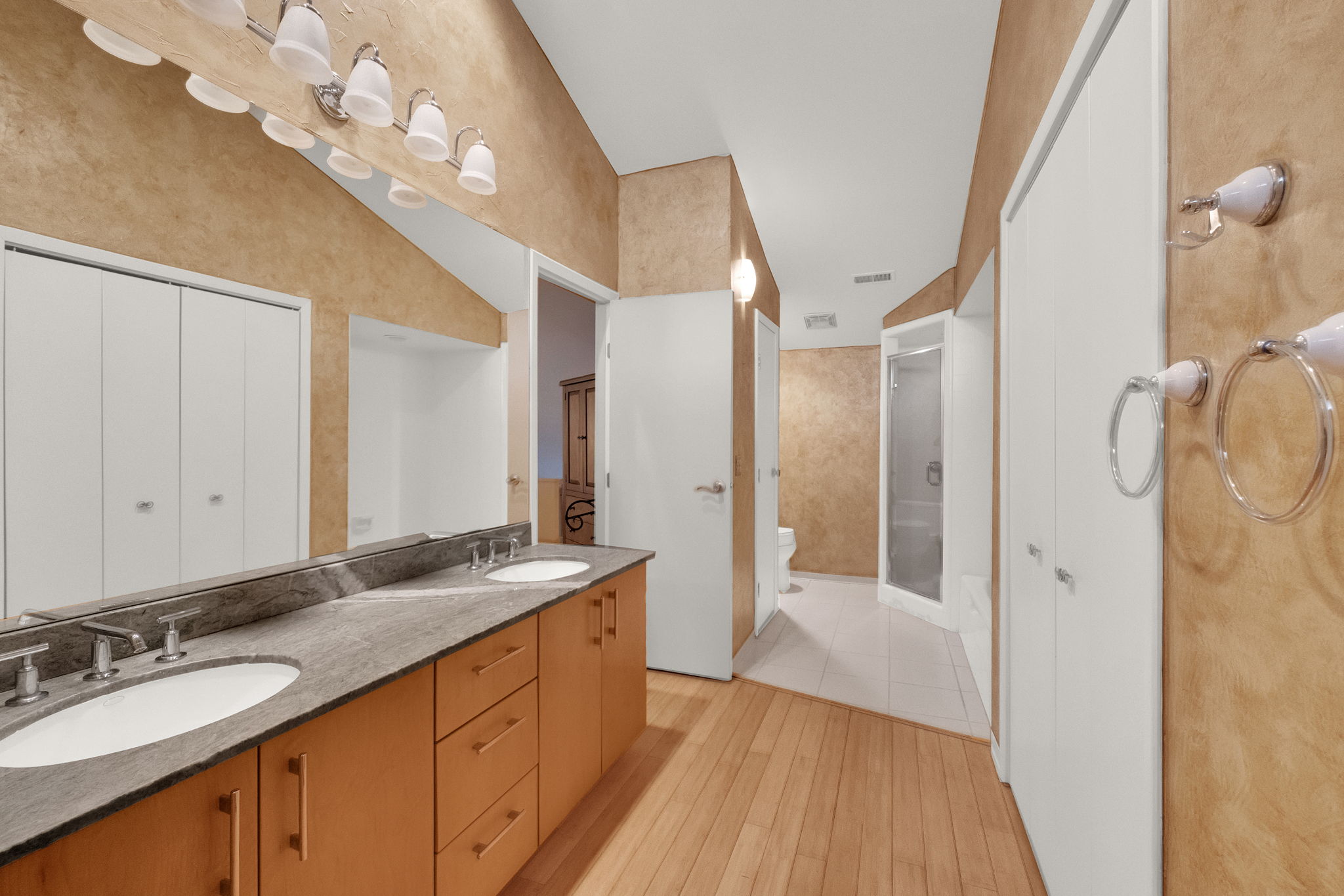 Double vanity with integrated sinks and brushed nickel faucets, set atop a stone countertop and wood-finish cabinetry