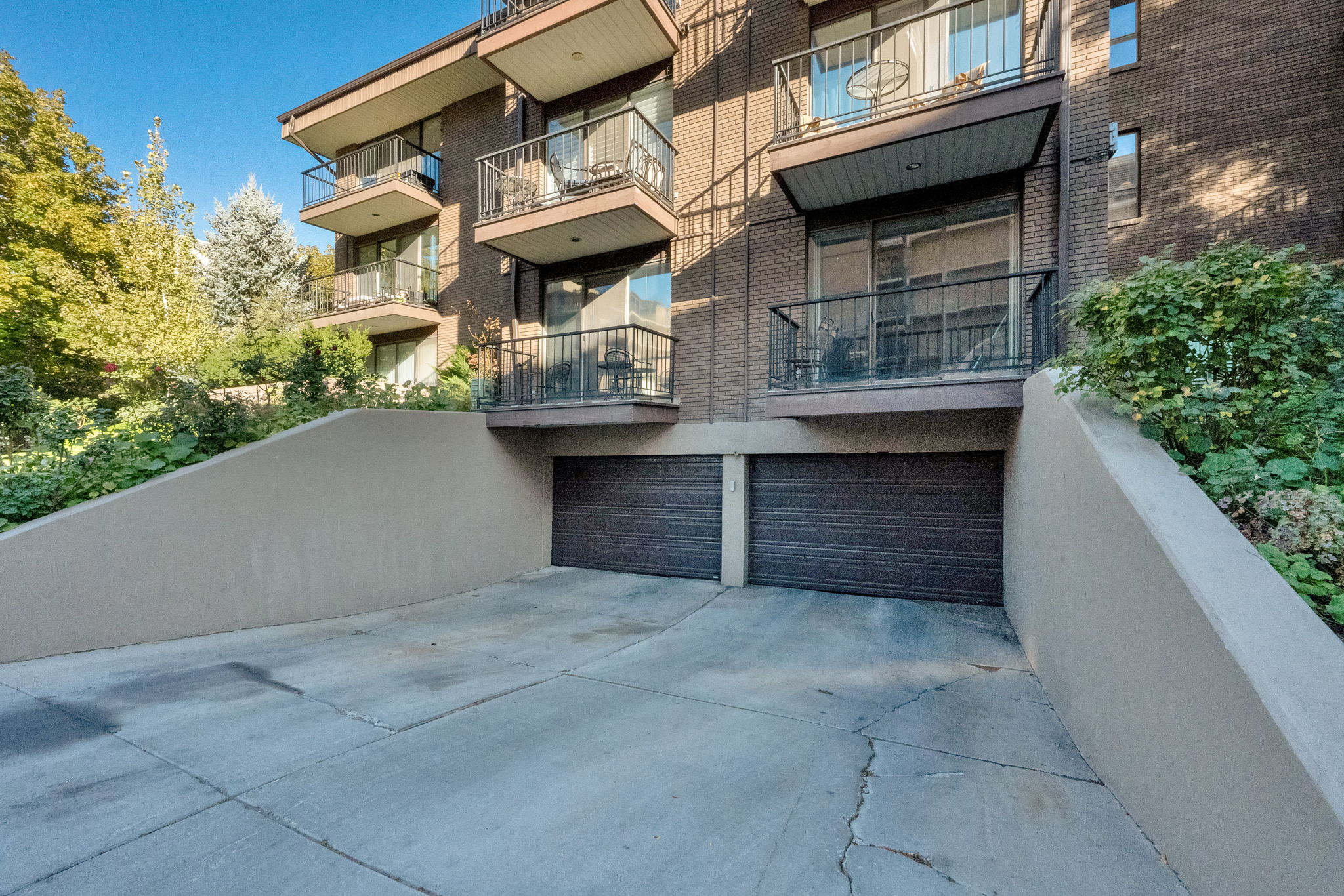 Multi-story brick facade building featuring two ground-level garage doors