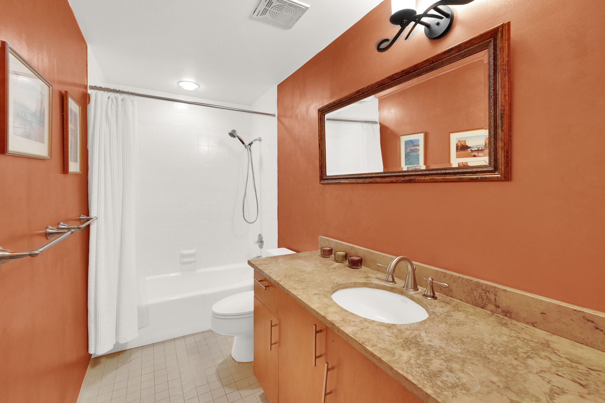 Bathroom featuring a vanity with an undermount sink, a stone-finish countertop, and wood-finish cabinetry