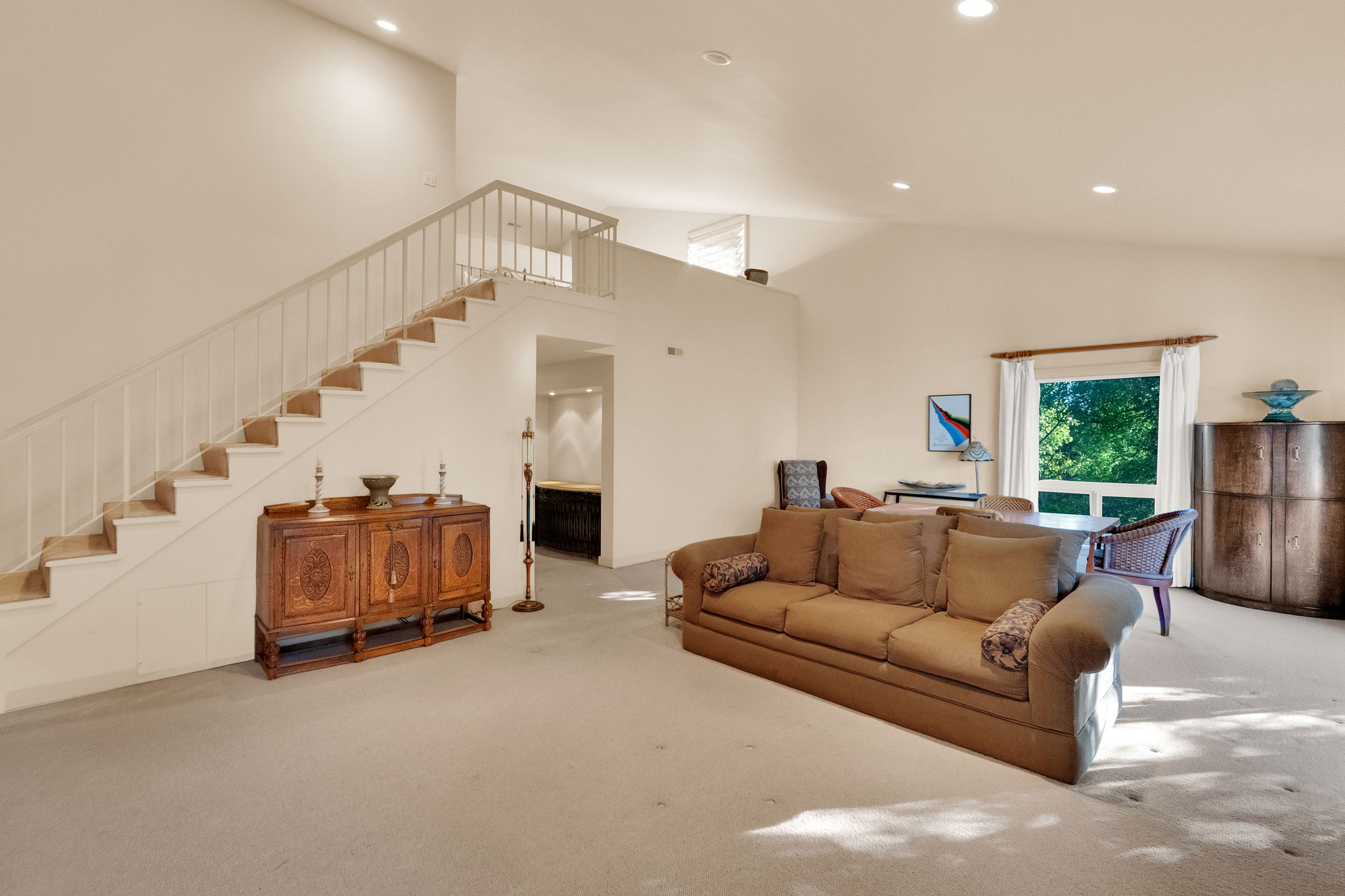 Expansive living area with vaulted ceilings and recessed lighting