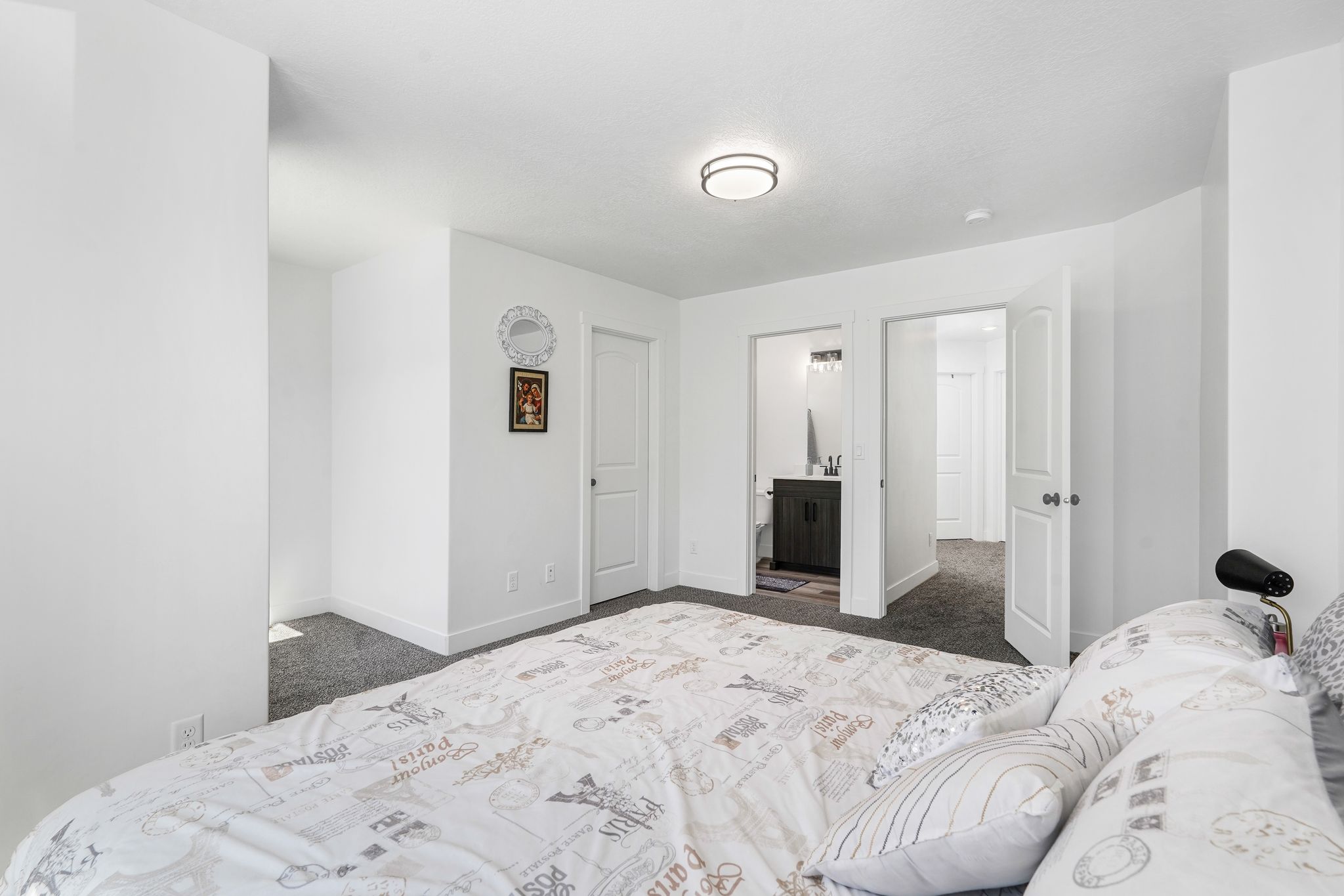 Carpeted bedroom with white walls and a contemporary ceiling light fixture