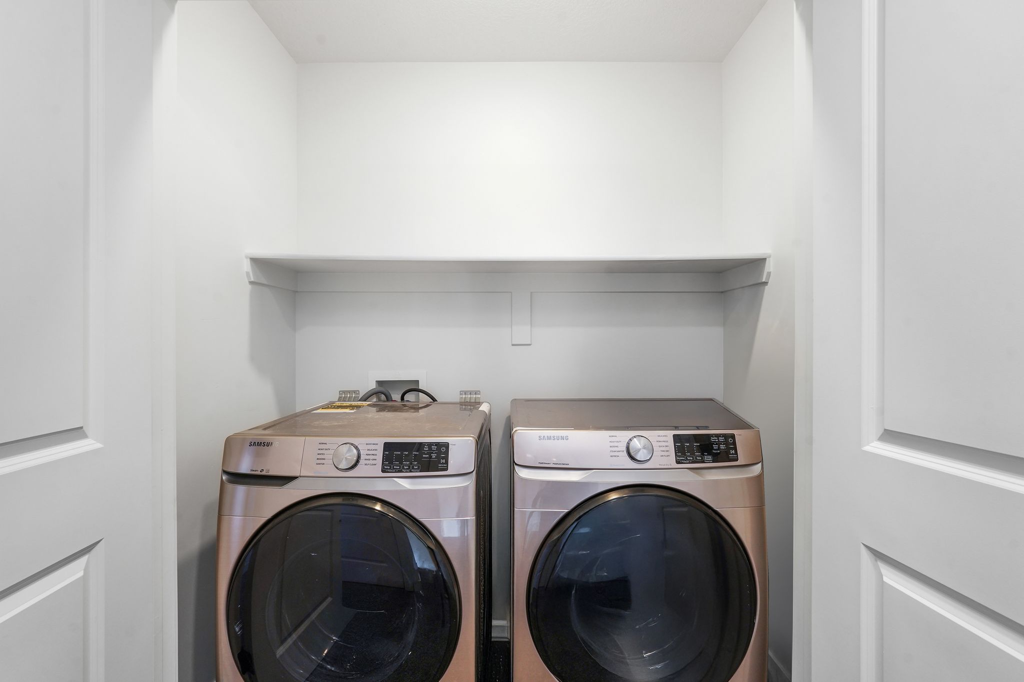 Dedicated laundry area featuring a built-in shelf and overhead lighting