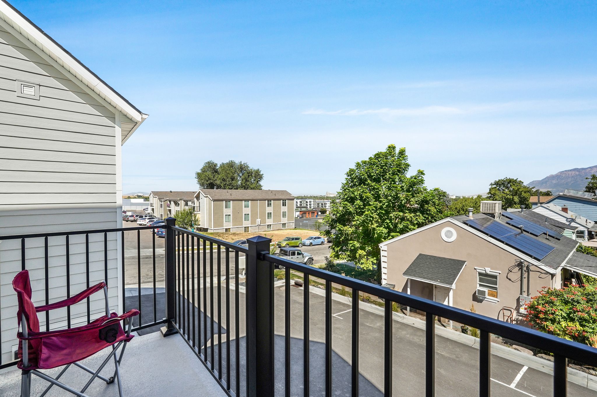 Private balcony with black wrought iron railings and a light gray concrete surface