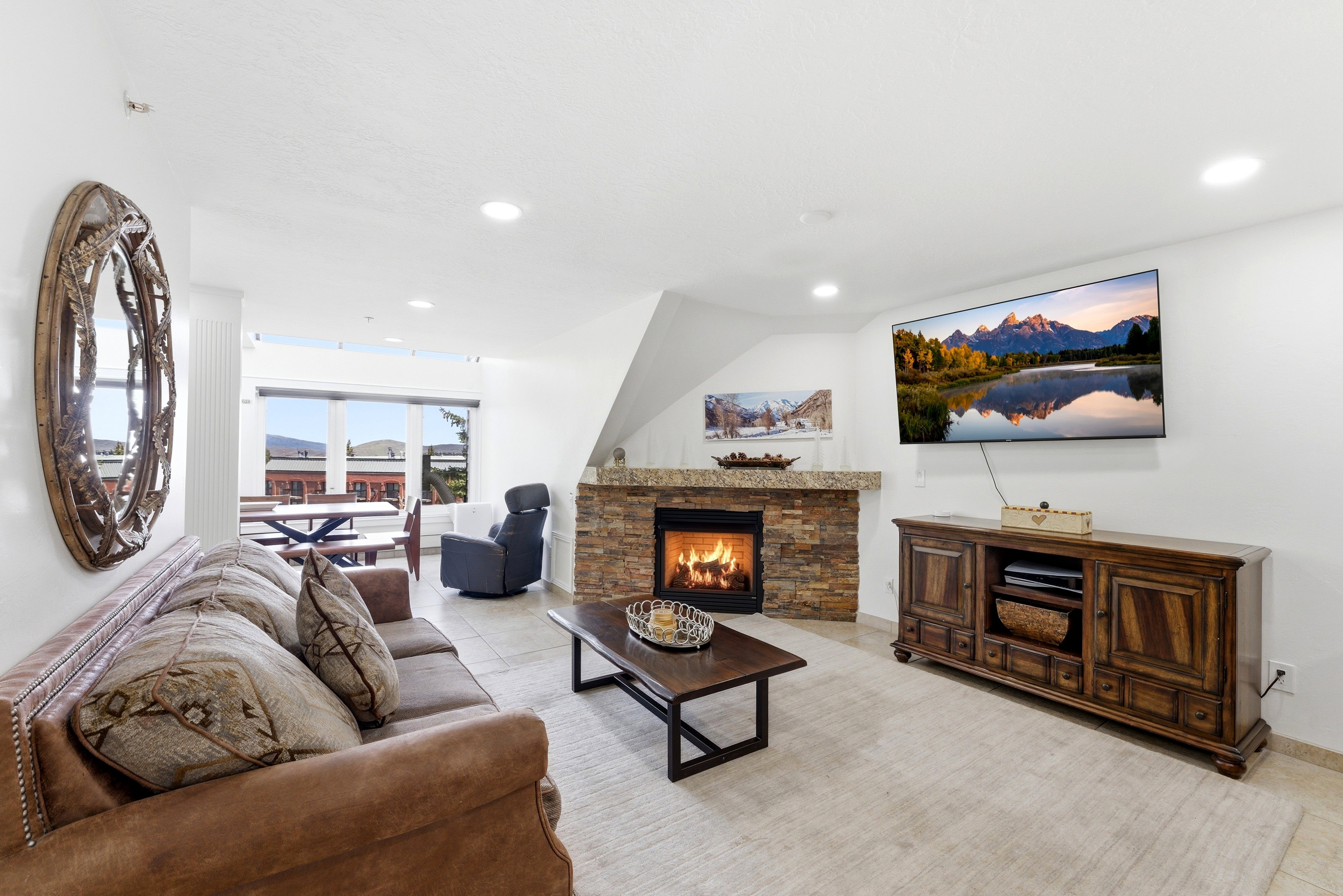 Living room with a stone fireplace, light tile patterned floors, and recessed lighting