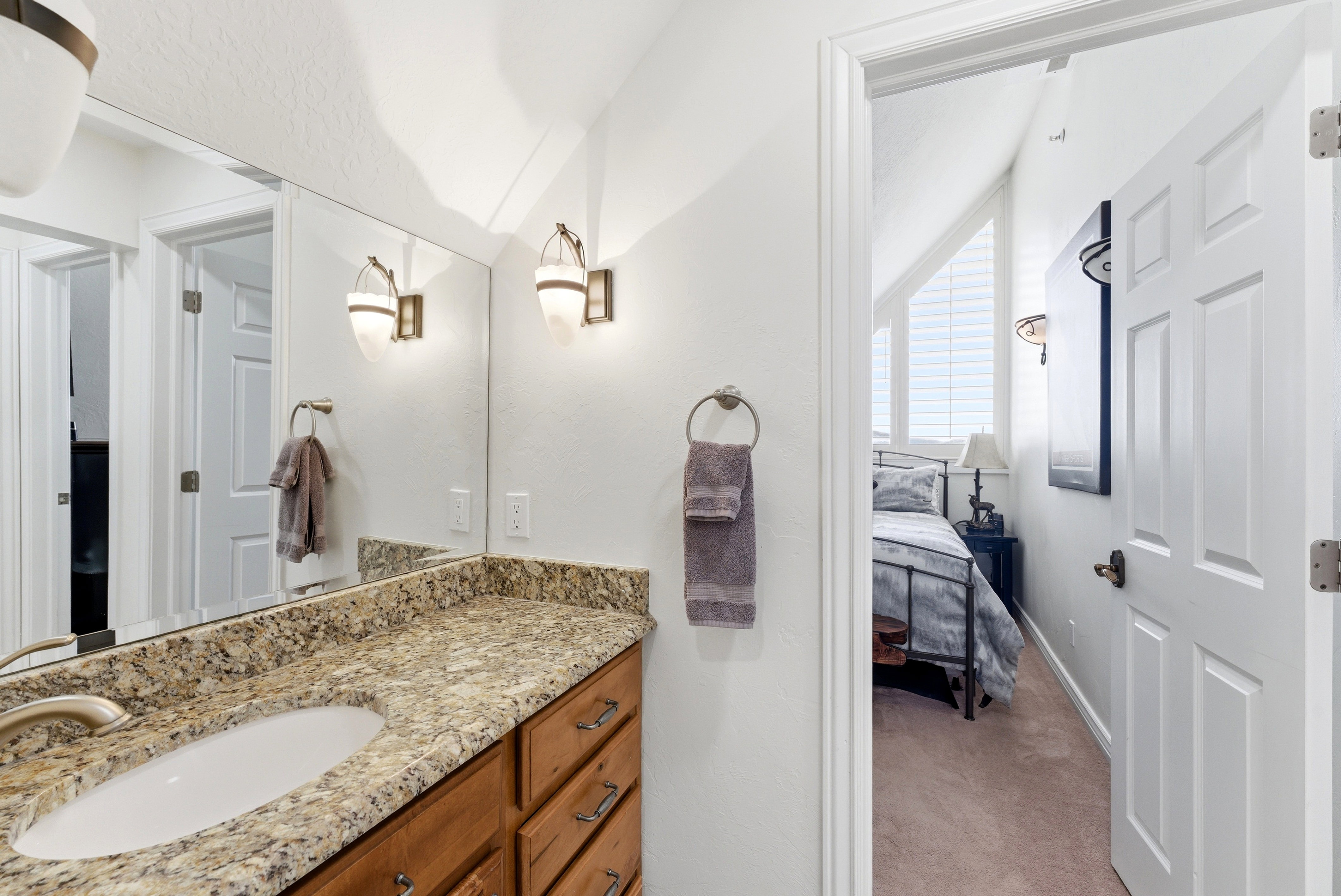 Ensuite bathroom featuring vanity and light colored carpet