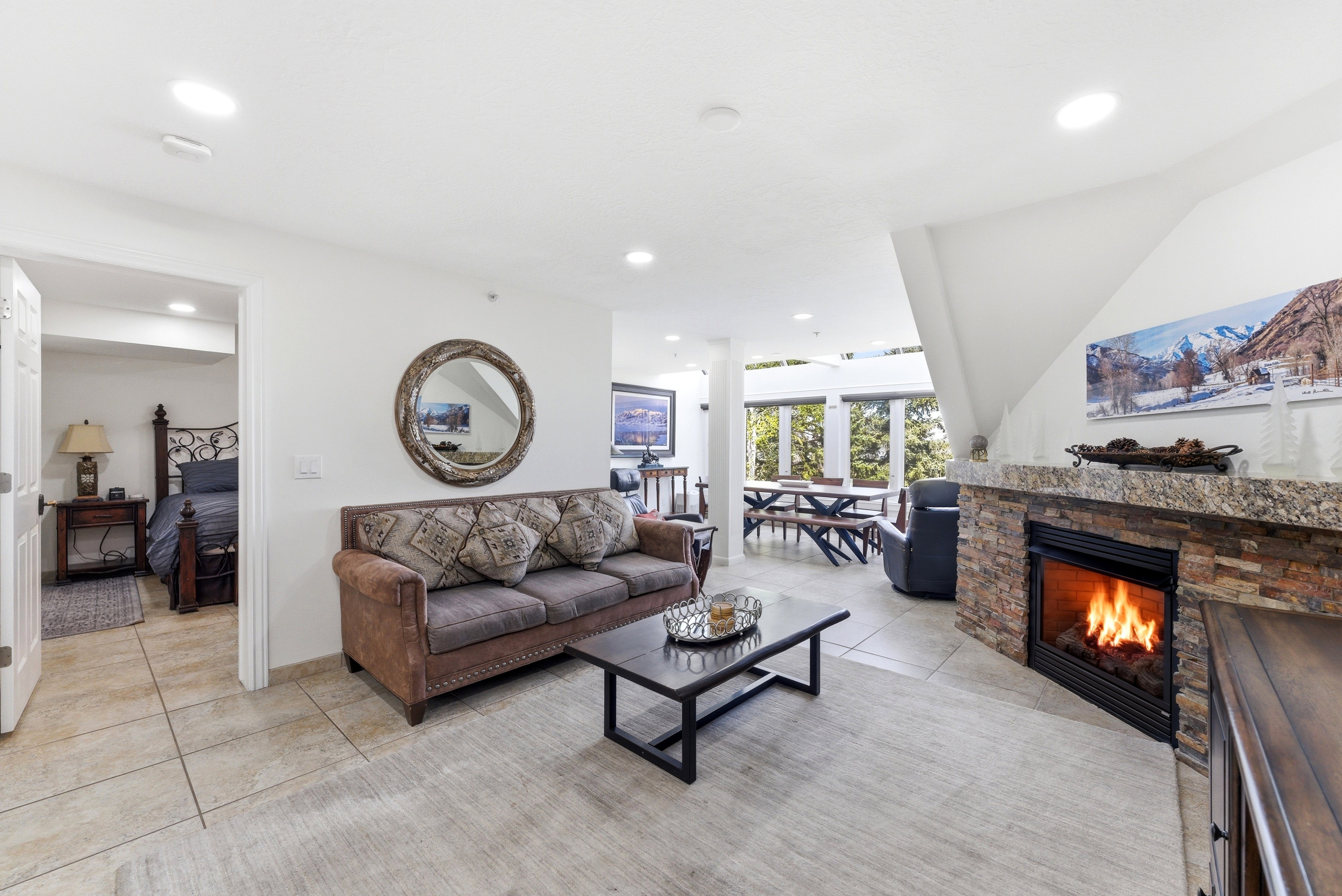 Living room with a fireplace, light tile patterned floors, and recessed lighting