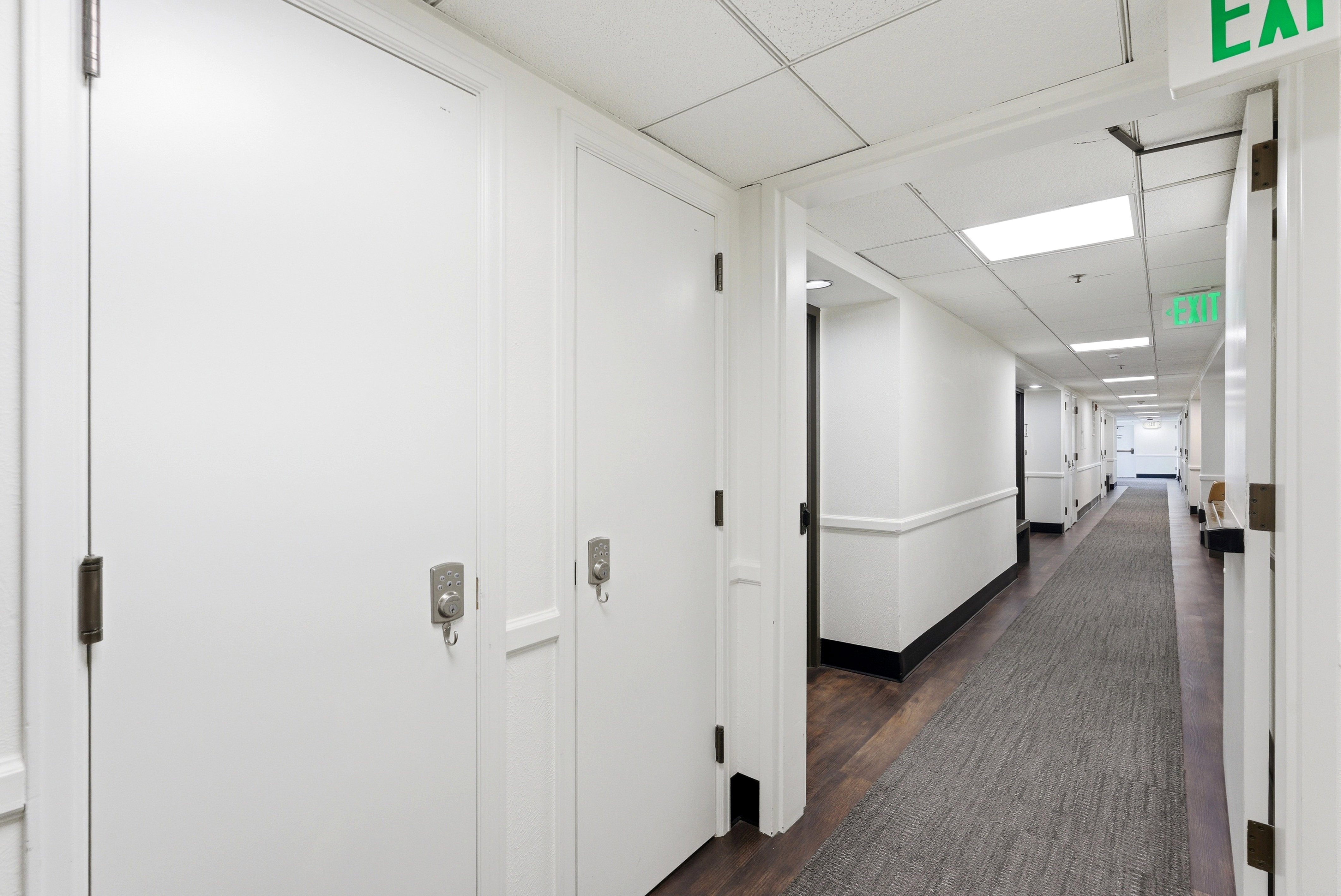 Corridor with a paneled ceiling and dark wood-style flooring