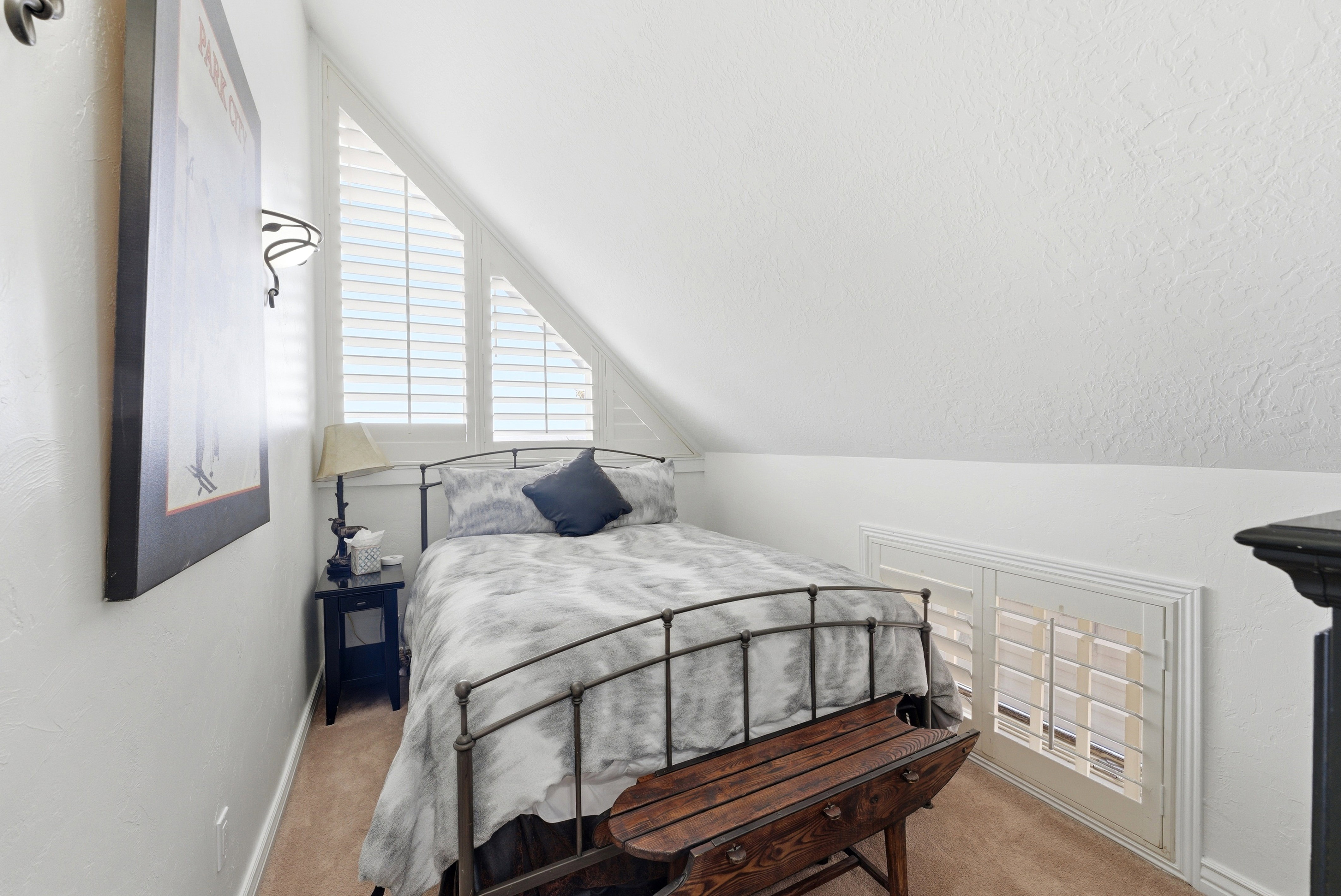 Carpeted bedroom with vaulted ceiling and baseboards