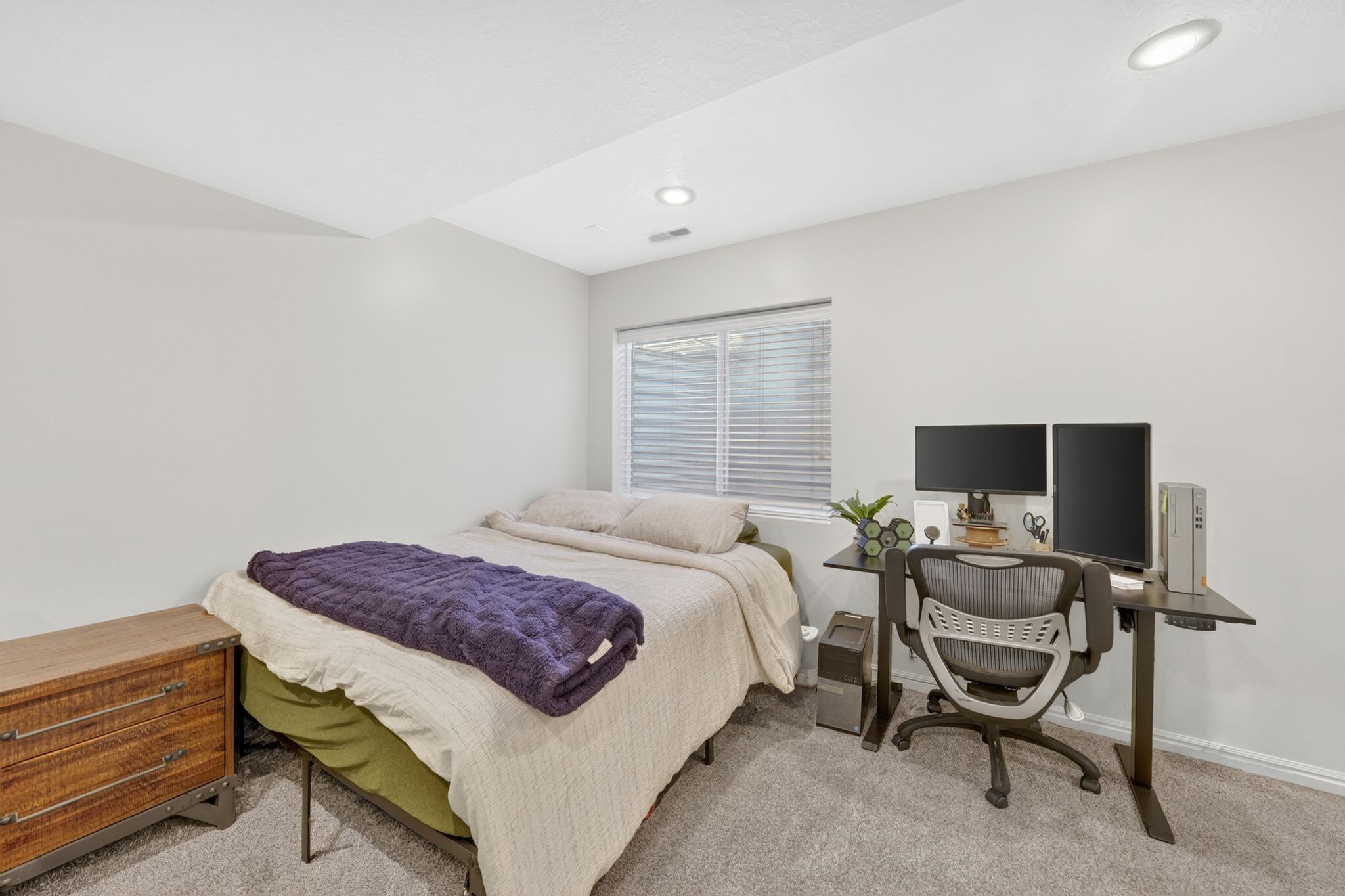 Bedroom featuring light gray walls, recessed lighting, a window with horizontal blinds, and gray carpet flooring
