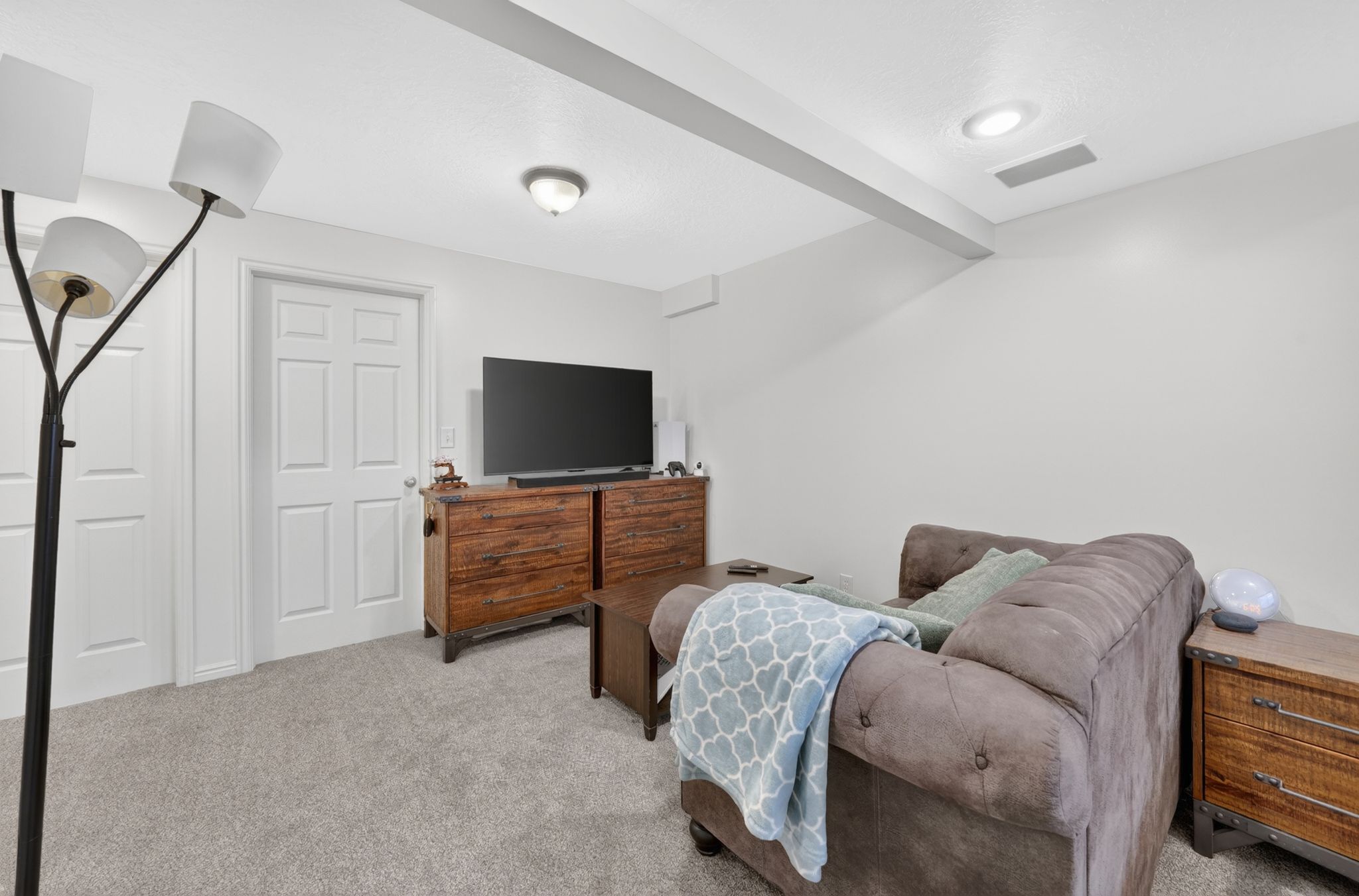 Carpeted living area featuring recessed lighting, a built-in speaker, and a ceiling-mounted light fixture