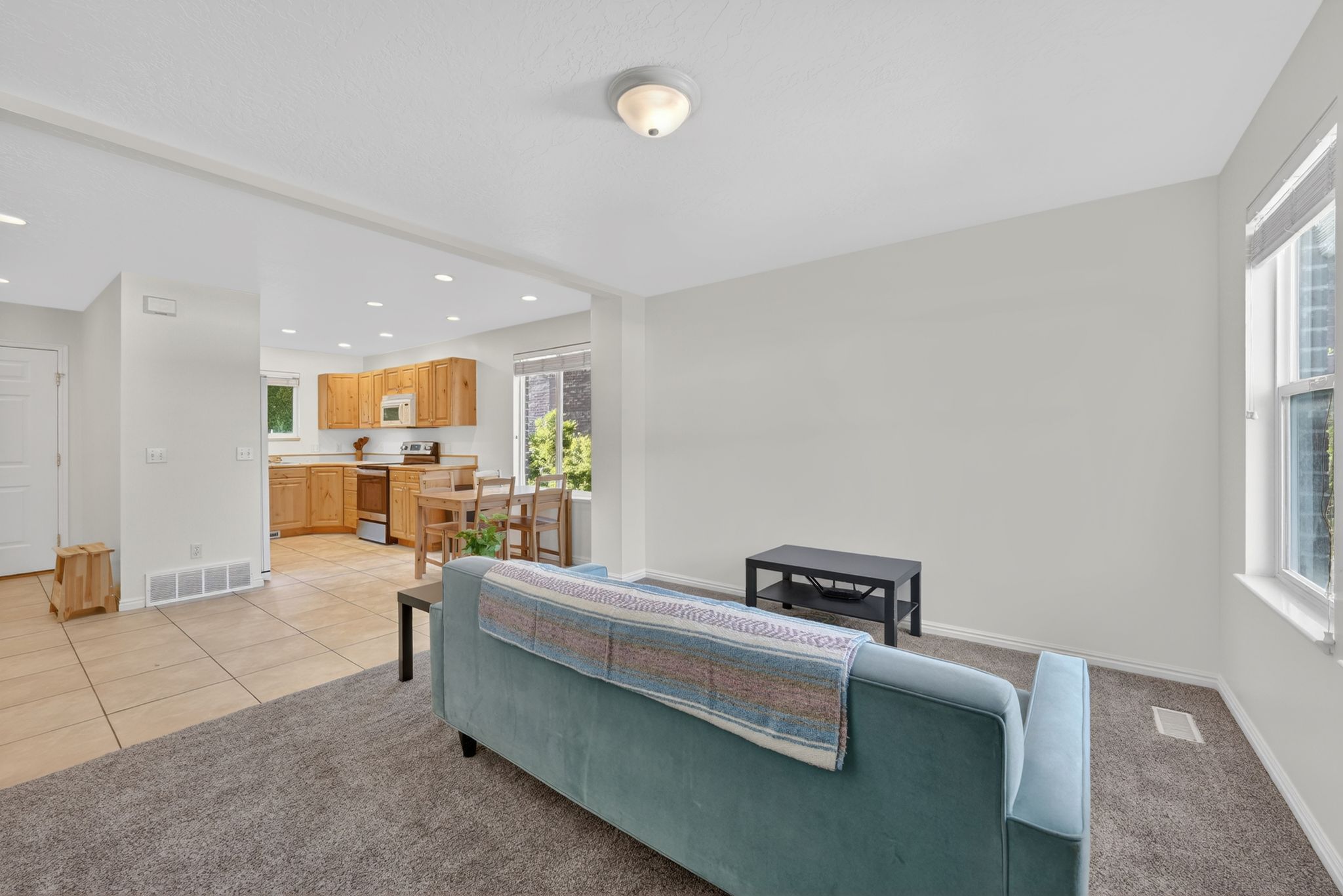 Bright living area with neutral wall tones and plush gray carpeting