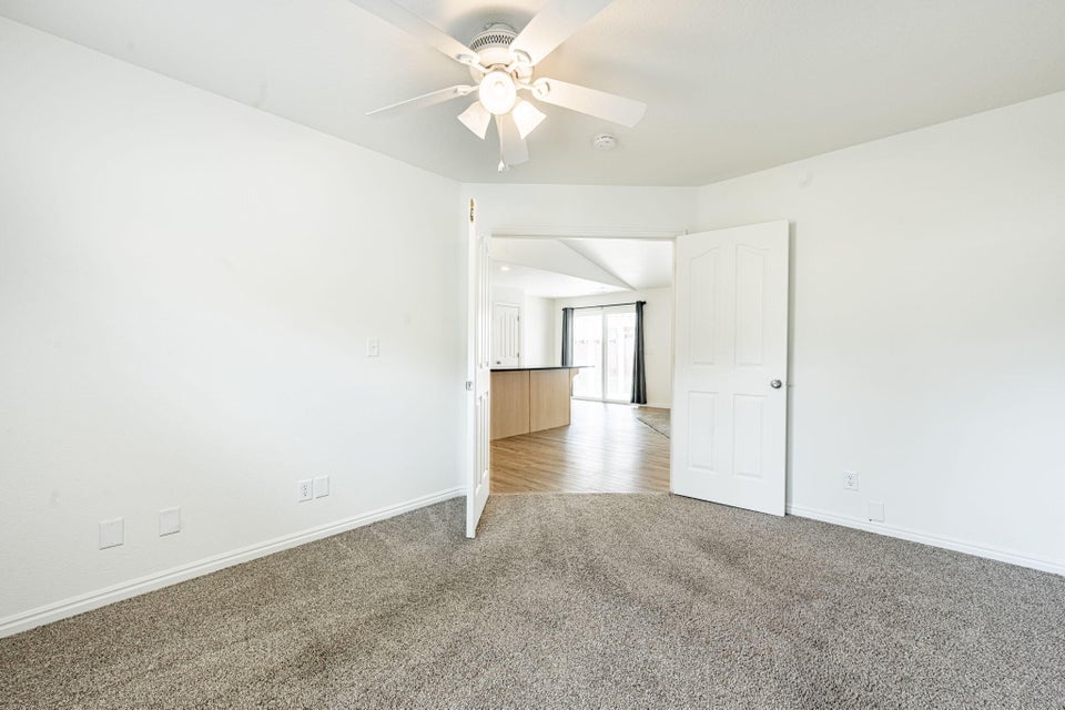Carpeted interior room with a ceiling fan light fixture