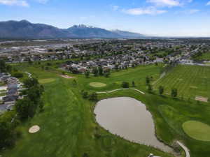 Expansive golf course setting featuring manicured greens, a prominent water feature, and sand traps