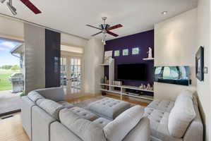 Living area featuring light wood-finish flooring and recessed ceiling lighting