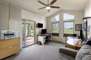 Carpeted interior space featuring a vaulted ceiling and a ceiling fan with integrated lighting