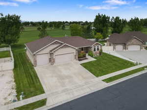 Contemporary ranch-style home featuring stone and stucco exterior, a two-car garage, and an additional single-car garage