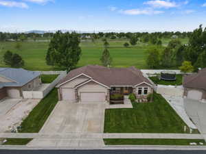 Ranch-style residence featuring a two-car garage, stone and stucco facade, and a concrete driveway