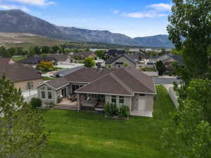 Expansive green lawn with a large rear deck featuring a covered patio