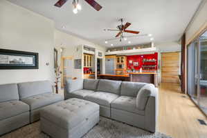 Open-concept living area featuring light wood-finish flooring, recessed lighting, and ceiling fans