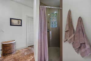 Walk-in shower featuring glass block window and chrome fixtures