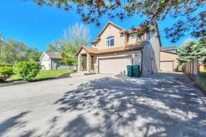Two-story residence featuring a stone-clad entry porch, attached two-car garage, and a separate detached garage structure