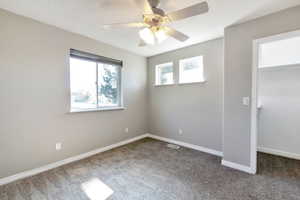 Spacious room featuring neutral grey walls and a ceiling fan with integrated lighting