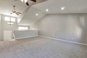 Spacious room featuring vaulted ceilings, recessed lighting, and a ceiling fan