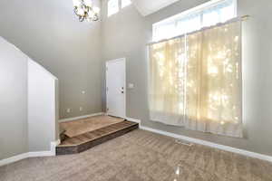Vaulted ceilings featuring an ornamental chandelier and upper transom windows