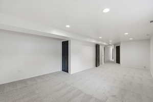 Spacious room with light gray carpet flooring and white walls