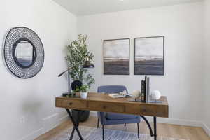 Light-filled room featuring recessed ceiling lighting, wood-finish flooring, and white baseboards