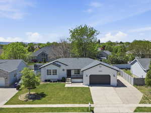 Single-story residence featuring a dark gray asphalt shingle roof and a two-car garage with a dark wood-finish door