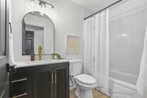 Contemporary bathroom with a black vanity featuring gold-finish hardware, a rectangular undermount sink, and a gold-finish faucet