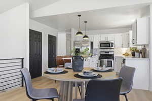 Open-concept dining area featuring wood-finish flooring