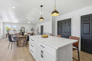 Kitchen island featuring a white countertop with subtle veining, shaker-style cabinetry, and matte black hardware