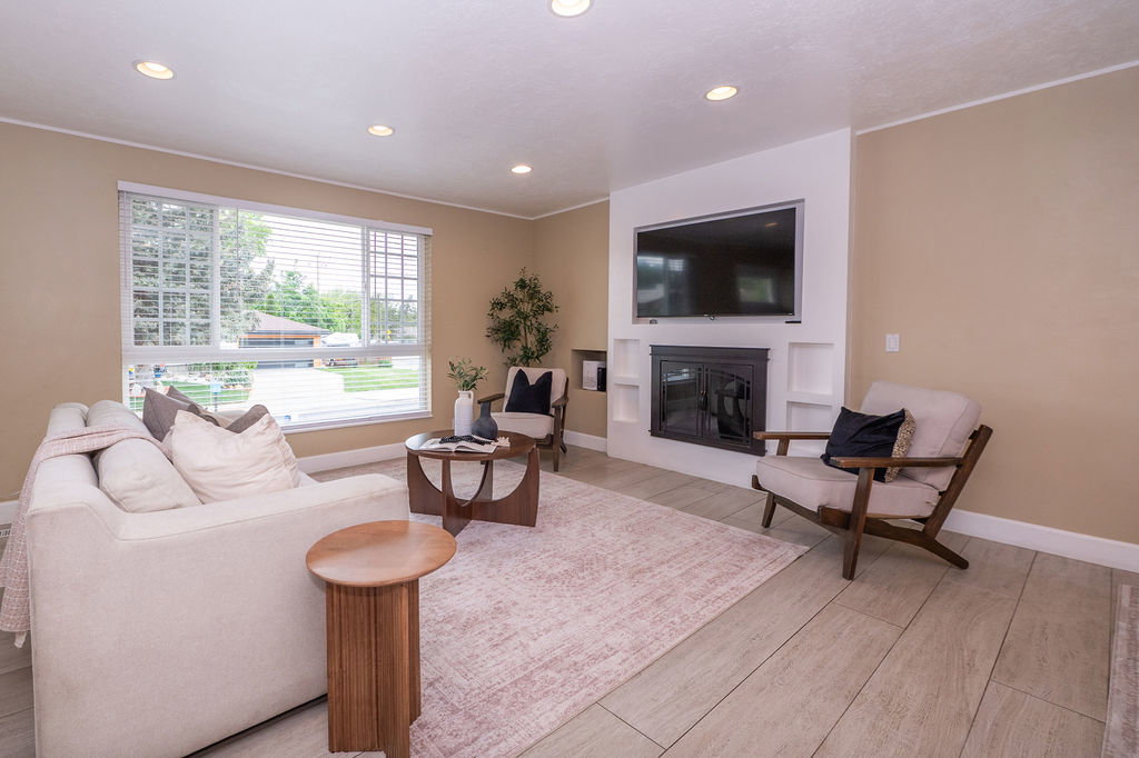 Living area featuring recessed lighting, a built-in fireplace with shelving, and light-toned wood-finish flooring