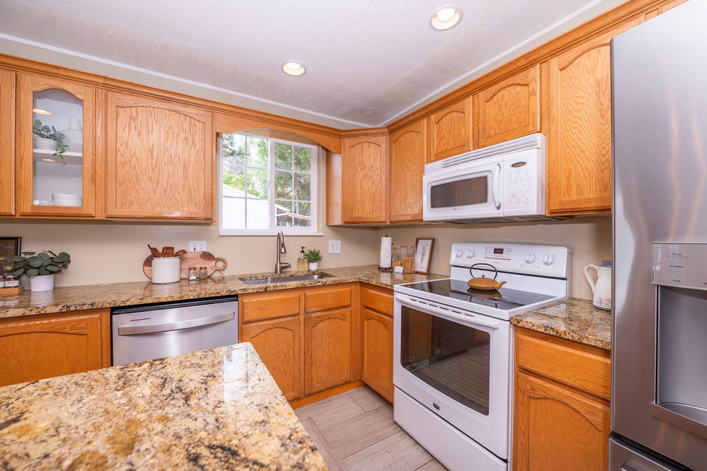 Kitchen featuring warm-toned wood cabinetry, granite countertops, and stainless steel appliances