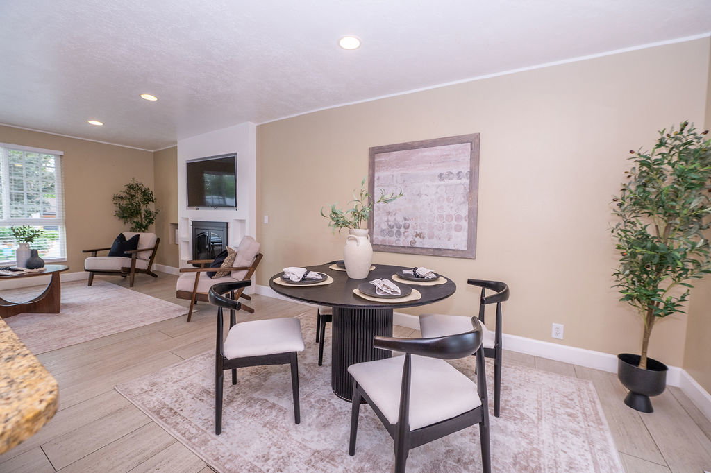 Open-concept living space featuring light beige walls, recessed lighting, and light wood-finish flooring