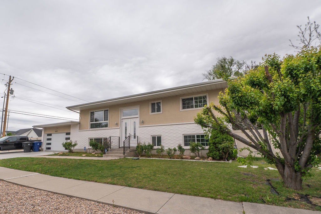 Featuring a textured stucco upper level and a painted brick lower level