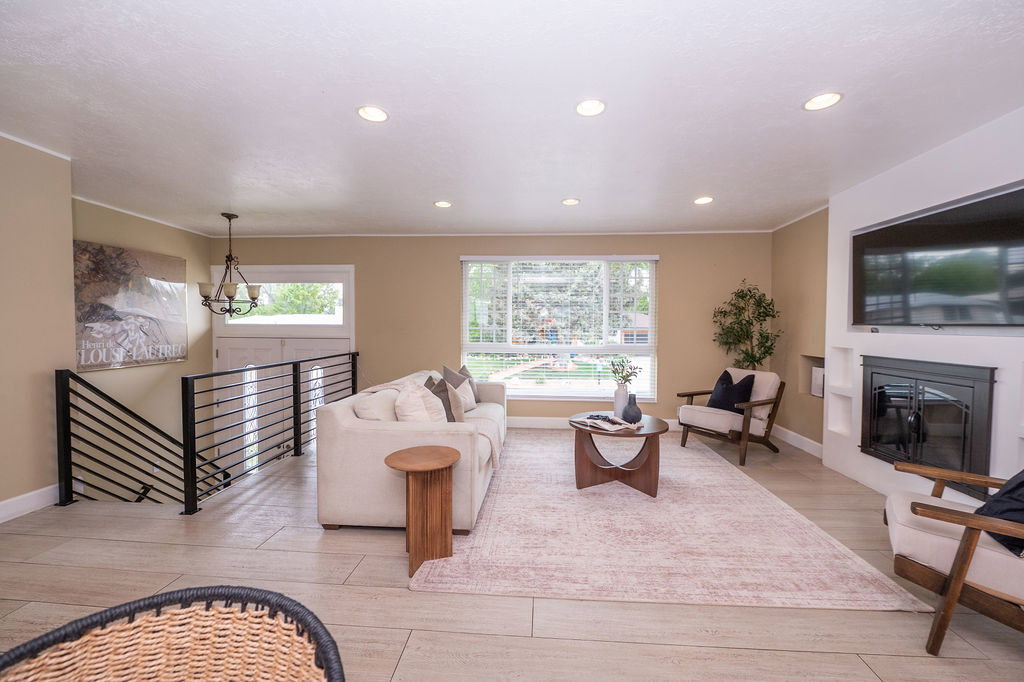 Spacious living area featuring large windows, recessed lighting, and wood-finish tile flooring