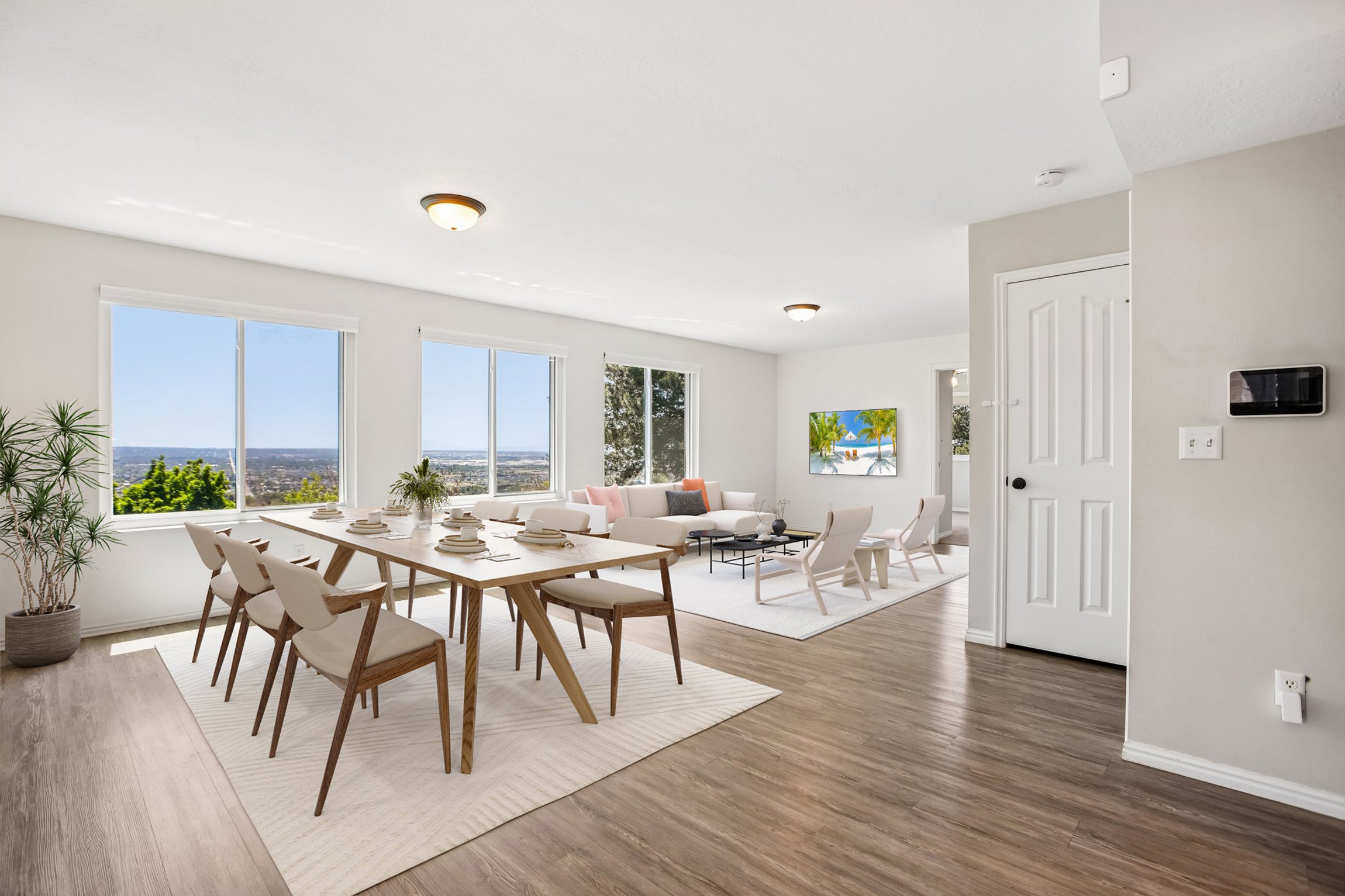 Open-concept interior featuring wood-finish flooring, multiple expansive windows with outdoor scenery, recessed lighting, and light-toned wall finishes