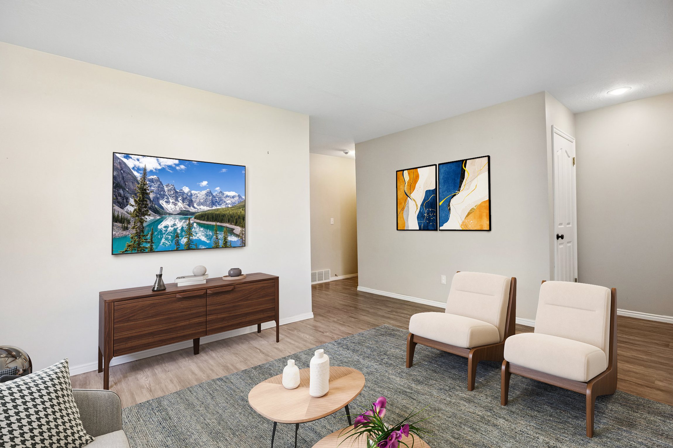 Spacious living area featuring light-toned walls, wood-finish flooring, and recessed lighting