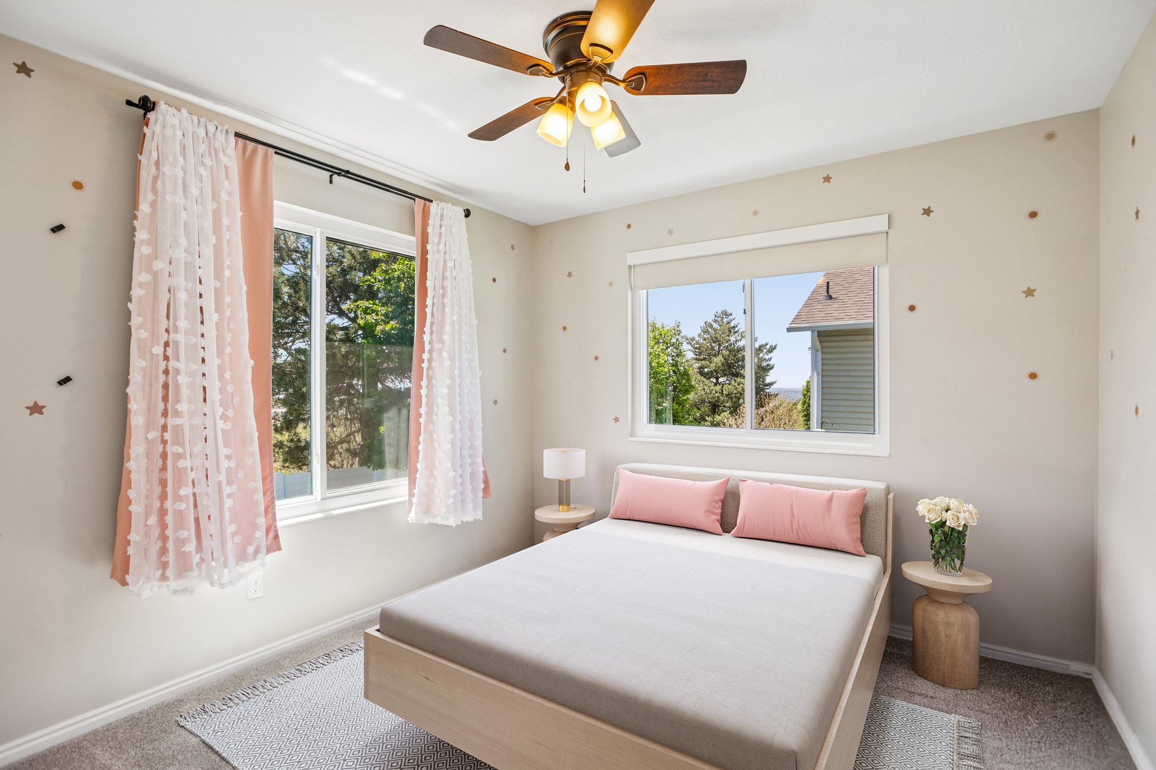 Bedroom featuring light neutral wall tones and a ceiling fan with integrated lighting